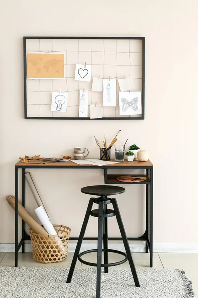 Comfortable workplace with mood board near light wall — Stock Photo, Image