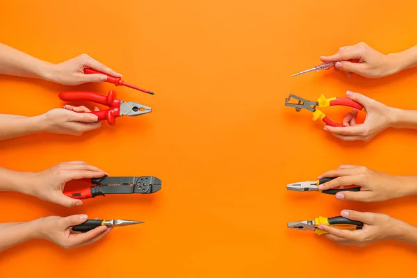 Female hands with set of electrician's supplies on color background — Stock Photo, Image