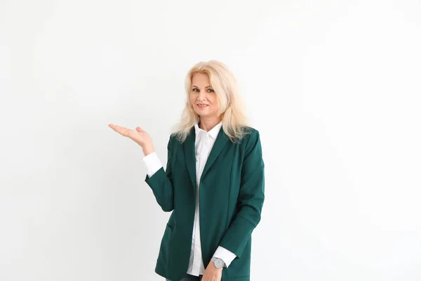 Stylish mature businesswoman showing something on white background — Stock Photo, Image