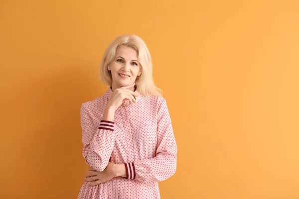 Portret van mooie rijpe vrouw op kleur achtergrond — Stockfoto