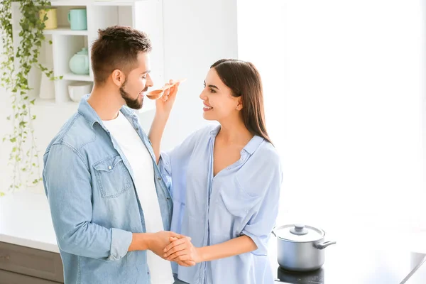 Belo casal jovem cozinhar juntos na cozinha em casa — Fotografia de Stock