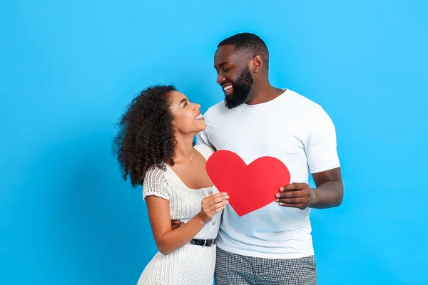 Portret van gelukkig Afro-Amerikaans paar met rood hart op kleur achtergrond — Stockfoto