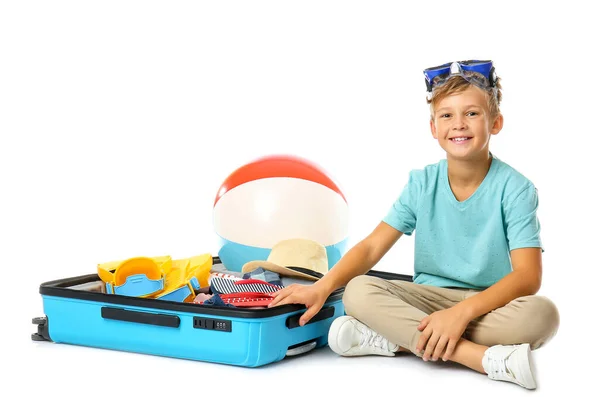 Lindo niño y maleta con cosas para las vacaciones de verano sobre fondo blanco — Foto de Stock