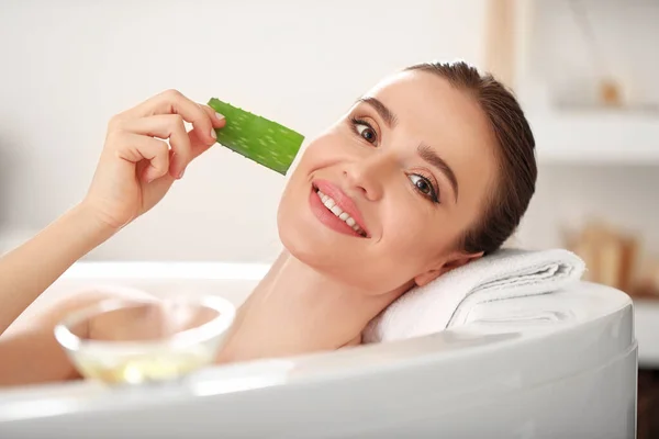 Güzel genç bir kadın banyoda aloe vera kullanıyor. — Stok fotoğraf