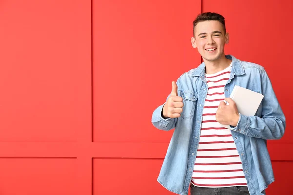 Cool teenage schoolboy showing thumb-up on color background — Stock Photo, Image