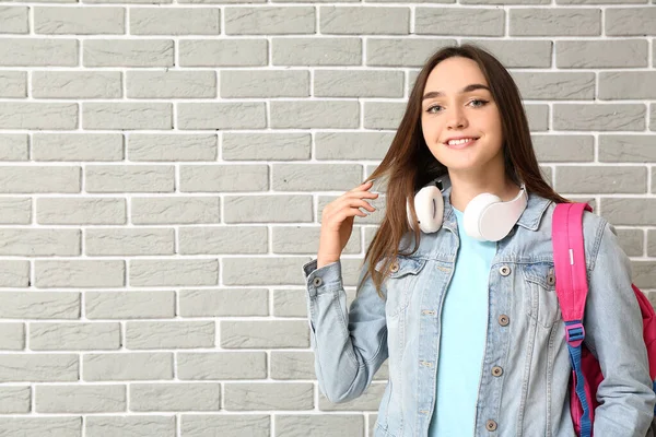 Beautiful female student on brick background — Stock Photo, Image