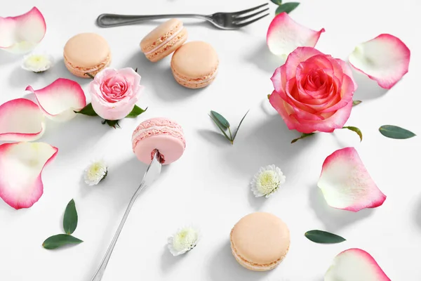 Вкусные макароны с розовыми цветами на белом фоне — стоковое фото