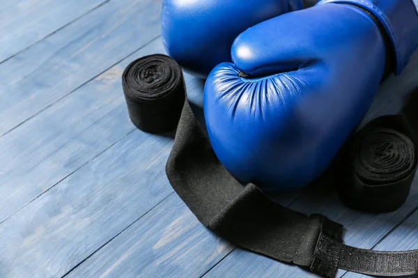 Boxing gloves and wrist bands on wooden background — Stock Photo, Image