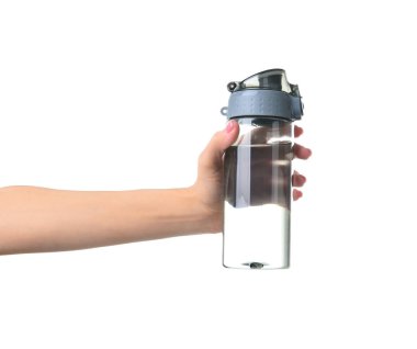 Beyaz arka planda su şişesi olan kadın eli.