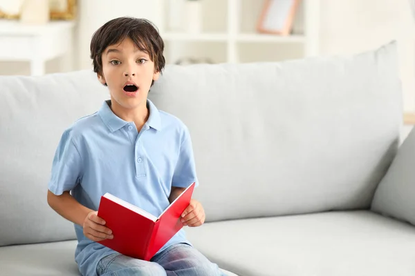 Kleiner Junge zu Hause mit Buch überrascht — Stockfoto