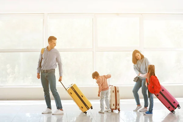 Happy family with luggage in airport — Stock Photo, Image