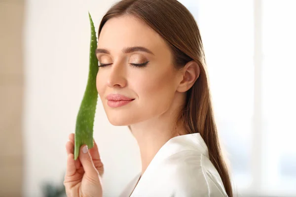 Beautiful young woman with aloe vera in bathroom — Stock Photo, Image