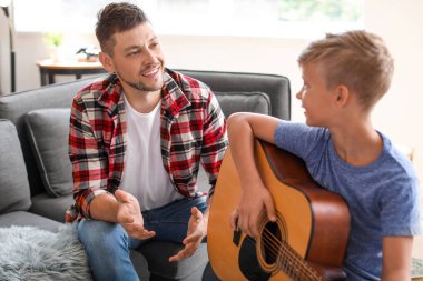 Baba evde gitar çalmayı küçük oğlu öğretim