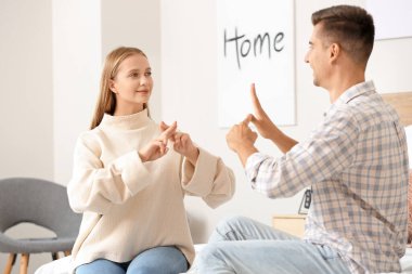 Evde işaret dili kullanan genç sağır ve dilsiz bir çift.