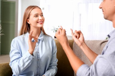 Evde işaret dili kullanan genç sağır ve dilsiz bir çift.