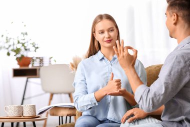 Evde işaret dili kullanan genç sağır ve dilsiz bir çift.