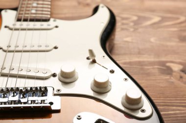 Ahşap arka planda modern bas gitar, yakın plan.