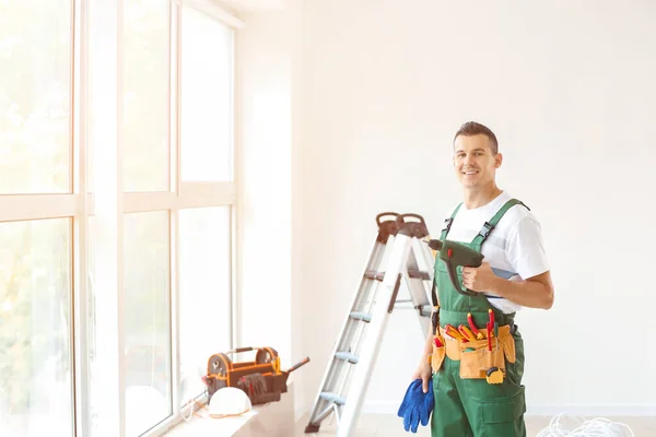 Electrician with tools in new empty apartment — Stock Photo, Image