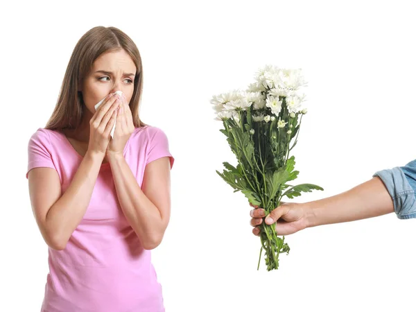 Man giving flowers to young woman suffering from allergy on white background — Stock Photo, Image