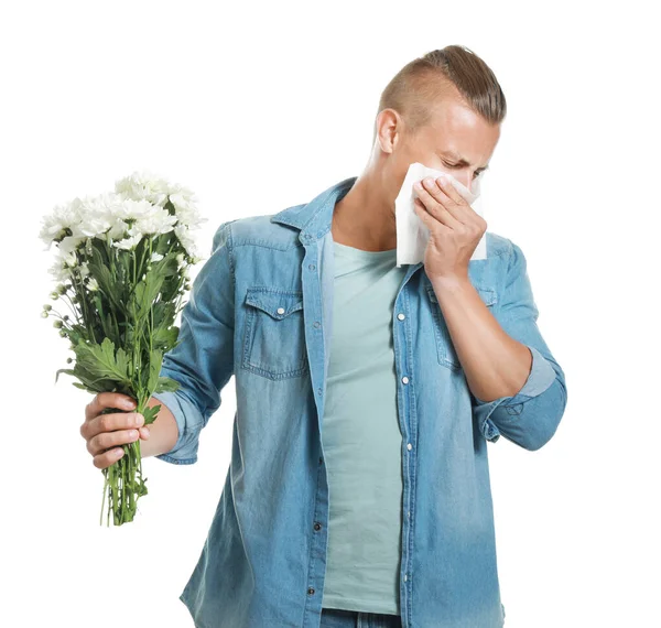 Young man suffering from allergy to flowers on white background — Stock Photo, Image