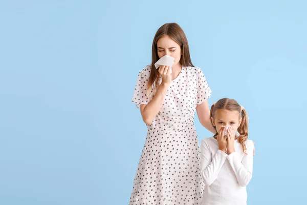Young woman and little girl suffering from allergy on light background — Stock Photo, Image