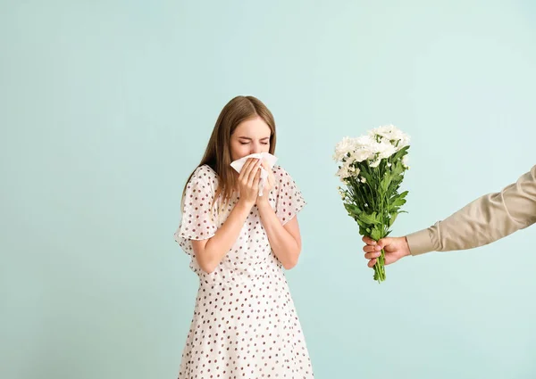 Hombre dando flores a la mujer joven que sufre de alergia en el fondo claro — Foto de Stock