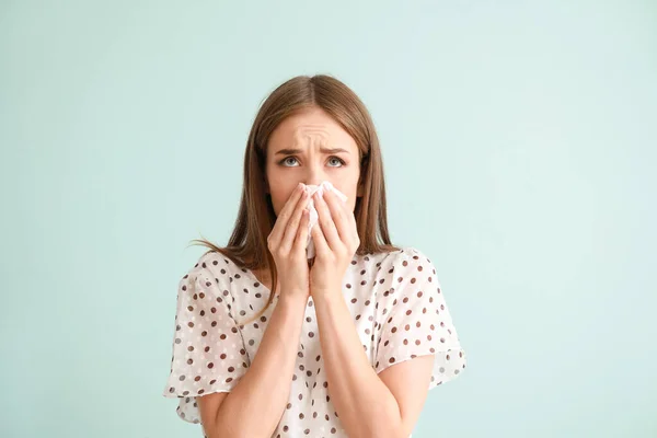 Mujer joven que sufre de alergia en un fondo claro —  Fotos de Stock