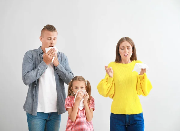 Giovane famiglia che soffre di allergia su sfondo chiaro — Foto Stock