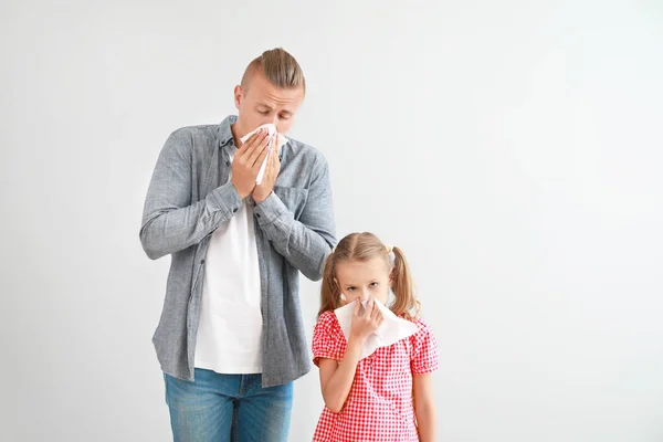 Young man and girl suffering from allergy on light background — Stock Photo, Image