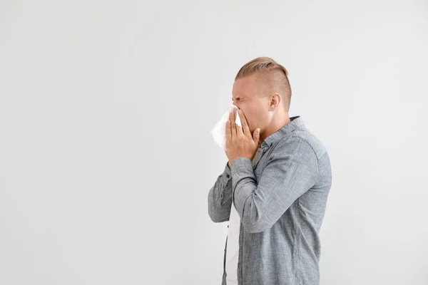 Young man suffering from allergy on light background — Stock Photo, Image