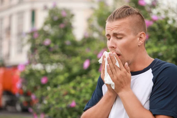 Young man suffering from allergy outdoors — Stock Photo, Image