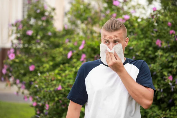 Hombre joven que sufre de alergia al aire libre — Foto de Stock