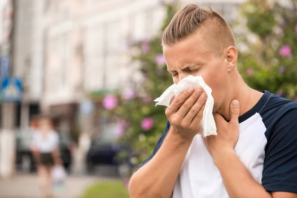 Young man suffering from allergy outdoors — Stock Photo, Image