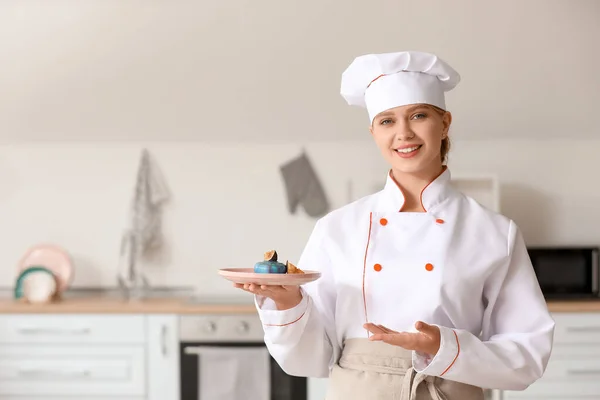 Female confectioner with tasty dessert in kitchen — ストック写真