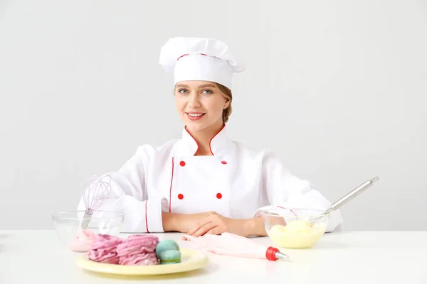 Жіночий кондитер з смачними десертами на світлому фоні — стокове фото