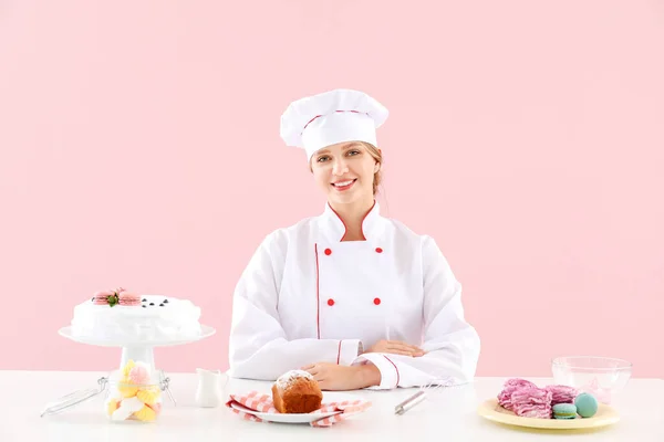 Pastelera femenina con sabrosos postres sobre fondo de color — Foto de Stock