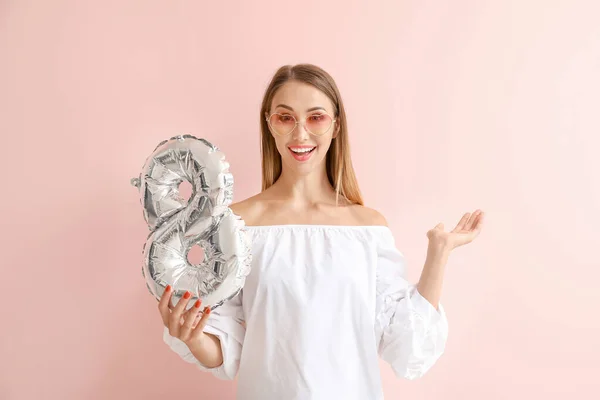 Beautiful young woman with figure 8 on color background. International Women's Day celebration — Stock Photo, Image