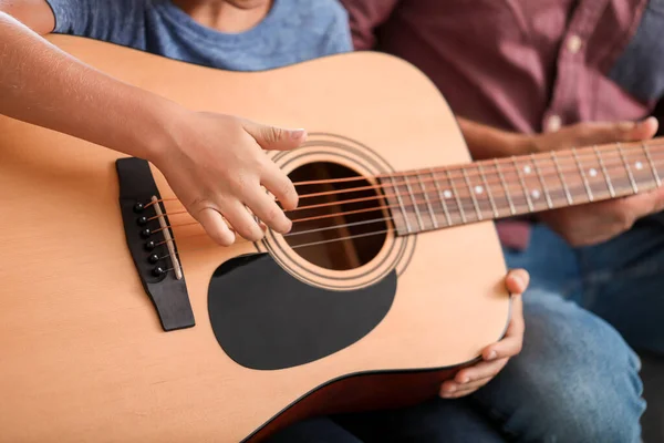 Petit garçon jouant de la guitare à la maison, gros plan — Photo