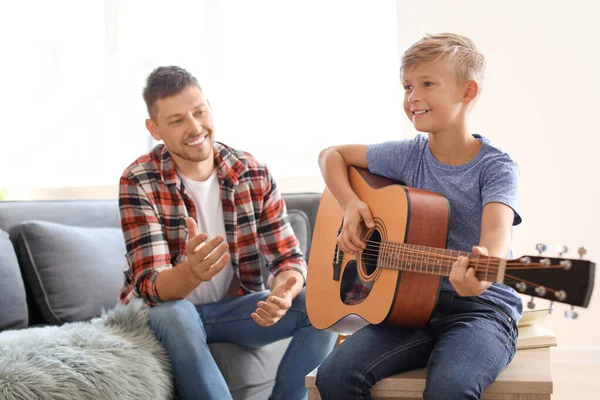 Father teaching his little son to play guitar at home — Stock Photo, Image