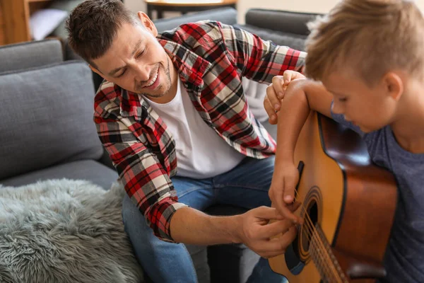 Father teaching his little son to play guitar at home — Stock Photo, Image