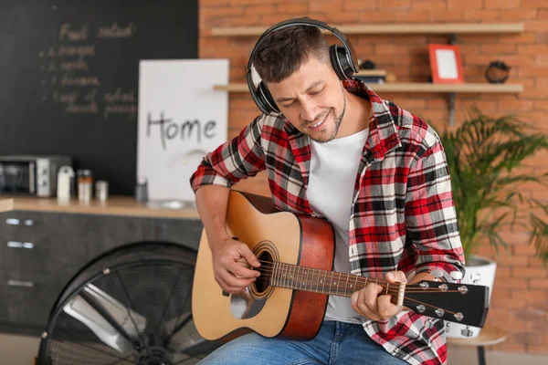 Schöner Mann spielt zu Hause Gitarre — Stockfoto