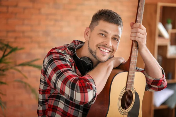 Handsome man with guitar at home — Stock Photo, Image