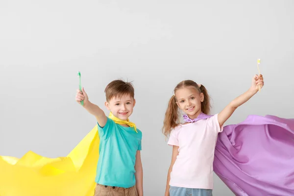 Portrait of little children brushing teeth on light background — Stock Photo, Image