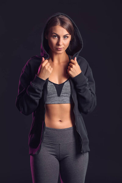 Sporty young woman on dark background