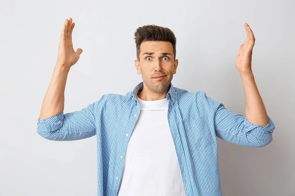 Stressed young man on light background — Stock Photo, Image