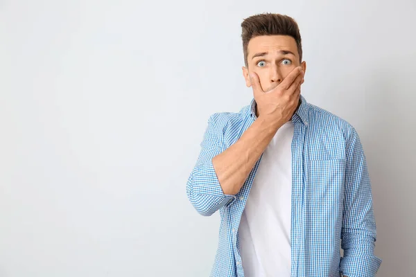 Surprised young man on light background — Stock Photo, Image