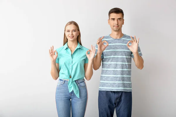 Jovem casal surdo mudo usando linguagem de sinais no fundo branco — Fotografia de Stock