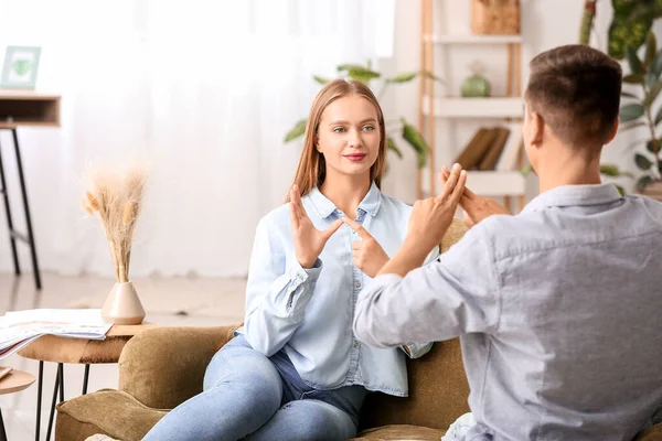 Giovane coppia sordomuta utilizzando il linguaggio dei segni a casa — Foto Stock