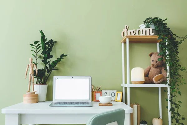 Modern stylish workplace with laptop near color wall — Stock Photo, Image