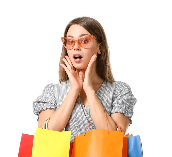 Surpreendida jovem mulher com sacos de compras no fundo branco — Fotografia de Stock